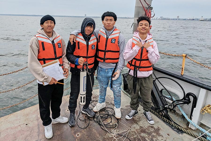 Group of High School Students on a Boat holding the Hydrolab.