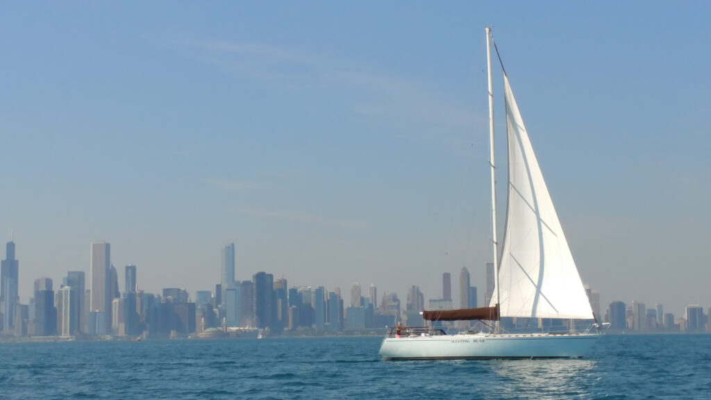 Sailboat in the water in front of the city of Chicago skyline.